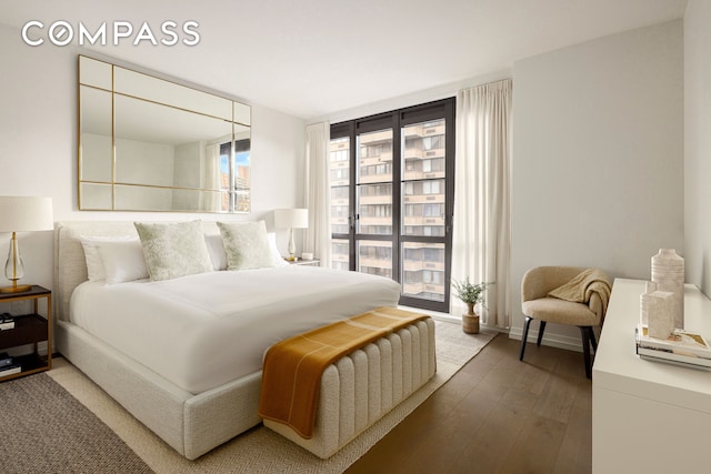 bedroom featuring multiple windows, baseboards, and hardwood / wood-style flooring