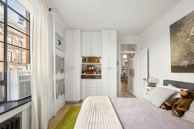 bedroom featuring light wood finished floors and ornamental molding