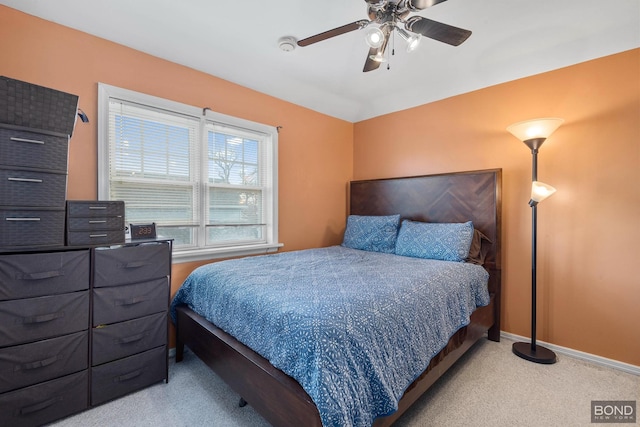 bedroom featuring a ceiling fan, light carpet, and baseboards