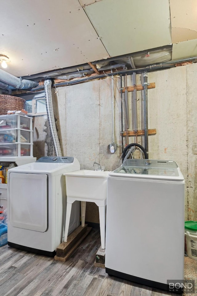 clothes washing area with laundry area, washer and clothes dryer, and wood finished floors