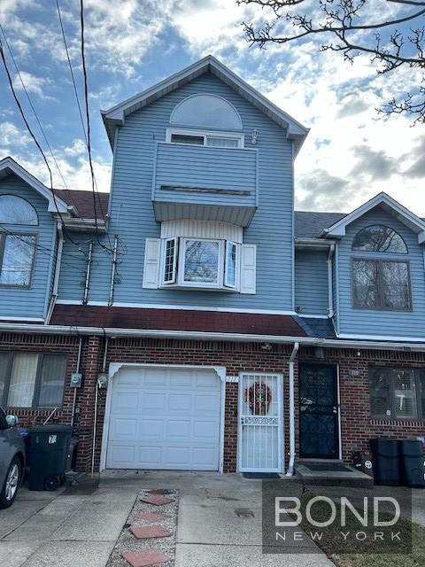 717 Annadale Rd, New York City, NY 10312 - view of property with an attached garage, driveway, and brick siding