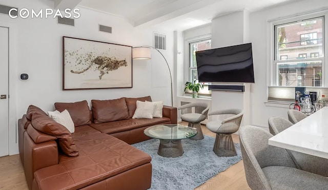 living room with beam ceiling, wood finished floors, and visible vents