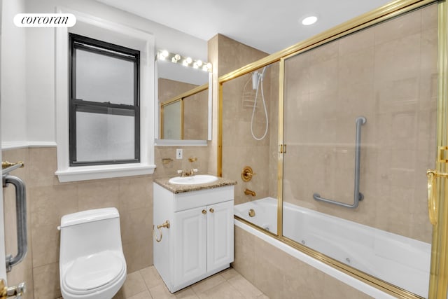 bathroom with tile walls, toilet, tile patterned floors, vanity, and tiled shower / bath