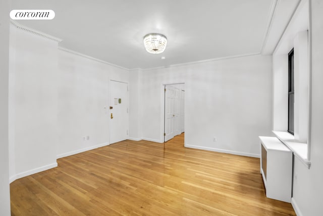 unfurnished room featuring light wood-type flooring, baseboards, visible vents, and crown molding