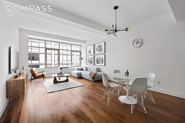 interior space featuring a notable chandelier, baseboards, and wood finished floors