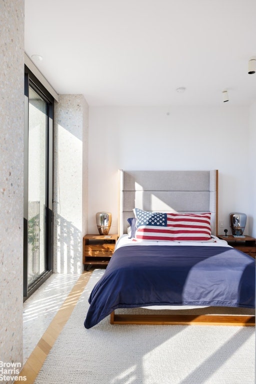 bedroom featuring hardwood / wood-style floors and floor to ceiling windows