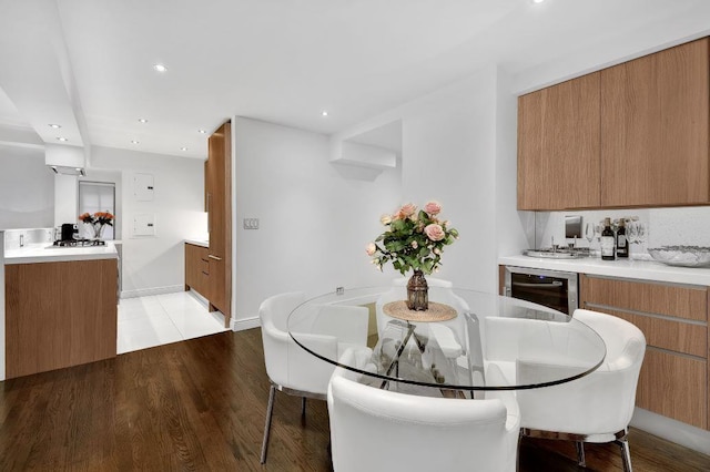 dining space featuring light wood-style floors, beverage cooler, baseboards, and recessed lighting