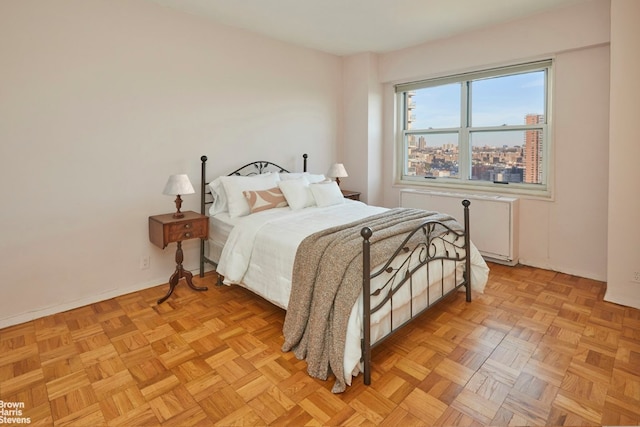 bedroom with baseboards and a city view