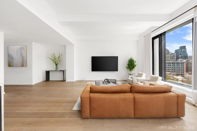 living room with beamed ceiling and light wood-type flooring