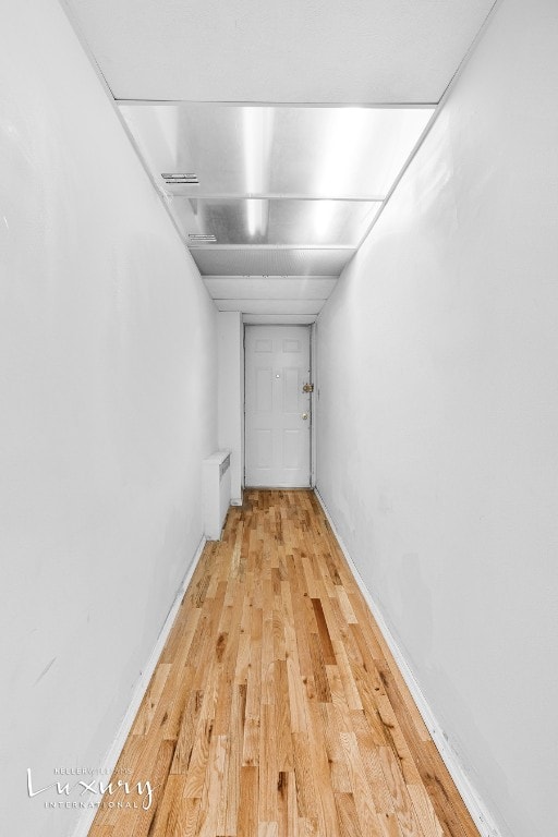 hall with radiator and light hardwood / wood-style flooring