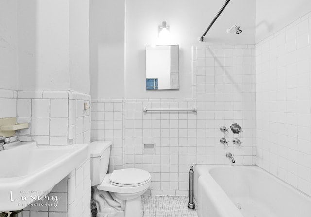 full bathroom featuring shower / bathing tub combination, tile patterned flooring, tile walls, and toilet