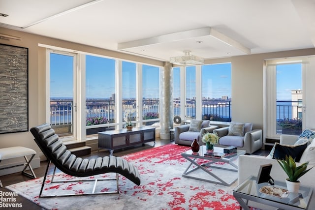 sunroom with a baseboard radiator and a water view