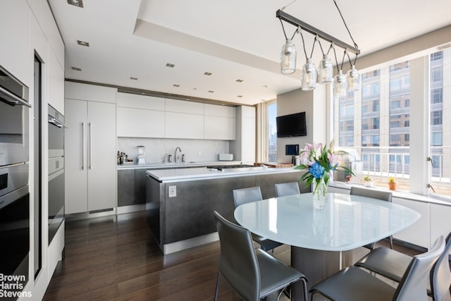 kitchen featuring sink, dark wood-type flooring, backsplash, and a healthy amount of sunlight