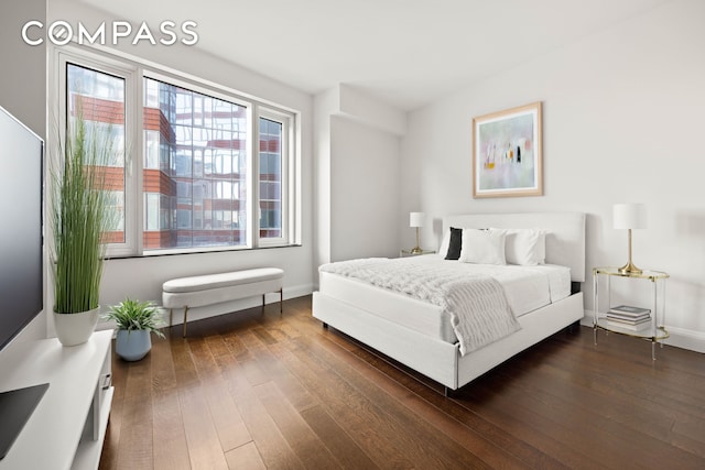 bedroom with dark wood-type flooring and baseboards