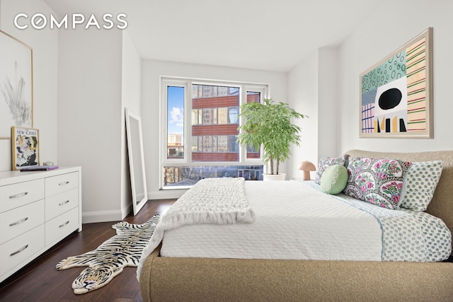 bedroom with baseboards and dark wood-style floors