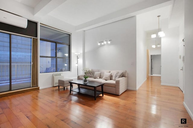 living room with hardwood / wood-style flooring, radiator heating unit, a chandelier, a high ceiling, and beamed ceiling