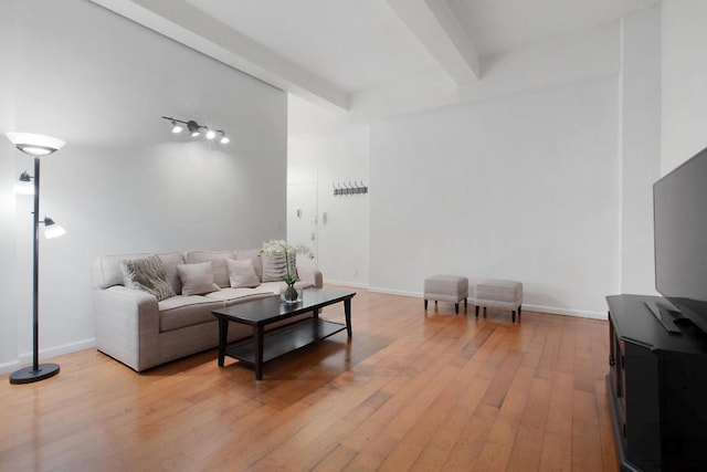 living room with beamed ceiling and light hardwood / wood-style floors