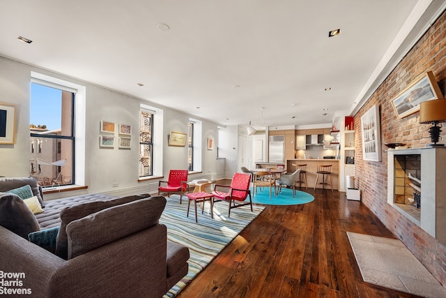 living room with brick wall and dark wood-type flooring