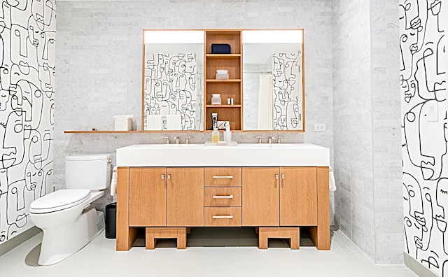 full bathroom featuring double vanity, tile patterned flooring, toilet, and tile walls