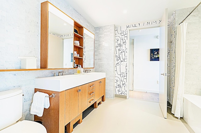 full bath featuring double vanity, toilet, and tile walls