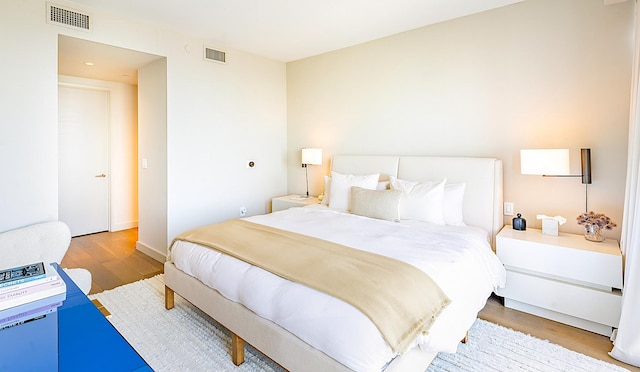 bedroom with light wood finished floors and visible vents