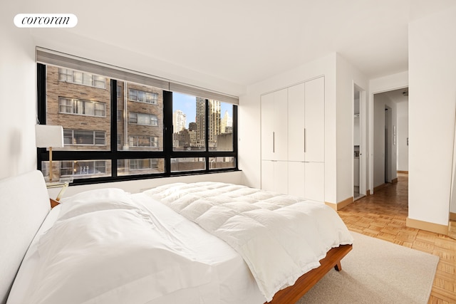 100 United Nations Plz Unit 7G, New York City, NY 10017 - bedroom with baseboards, a closet, and a view of city