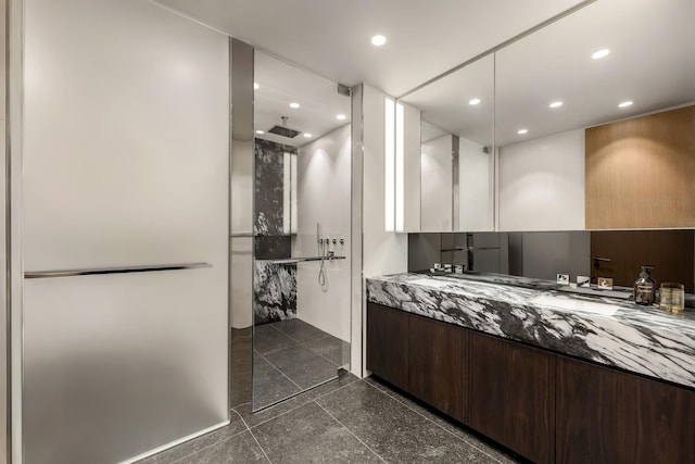 bathroom with a stall shower, granite finish floor, vanity, and recessed lighting