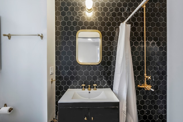 bathroom featuring vanity, a shower with shower curtain, tile walls, and backsplash