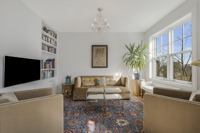 living room with built in shelves and a notable chandelier