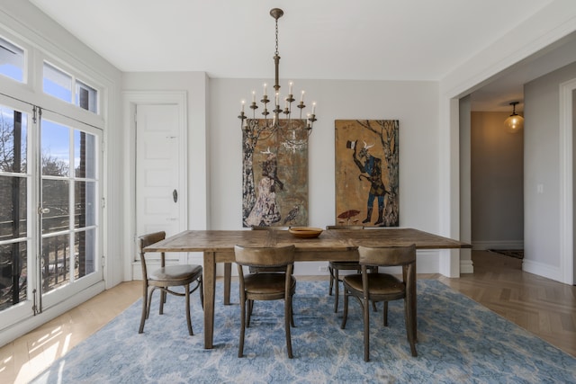 dining area with parquet flooring and a chandelier