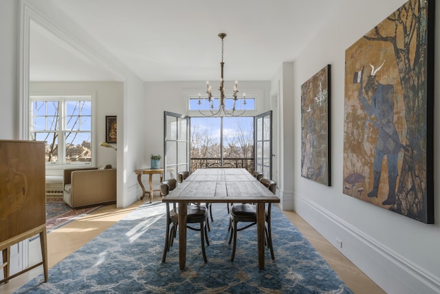 dining area with a notable chandelier and light hardwood / wood-style floors