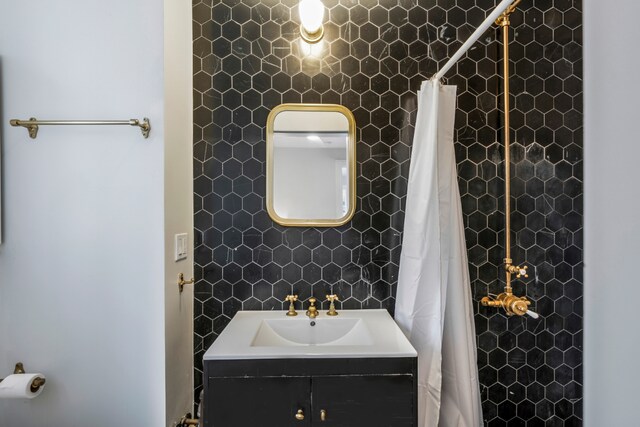 bathroom with walk in shower, tile walls, vanity, and decorative backsplash