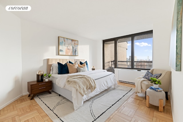 bedroom with visible vents, a city view, and baseboards