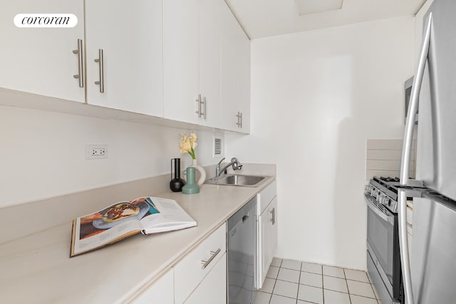 kitchen with appliances with stainless steel finishes, light countertops, white cabinets, and a sink