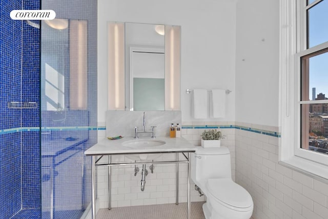 bathroom featuring tile walls, sink, and toilet