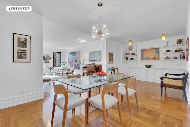 dining space featuring built in features, a chandelier, and light parquet flooring