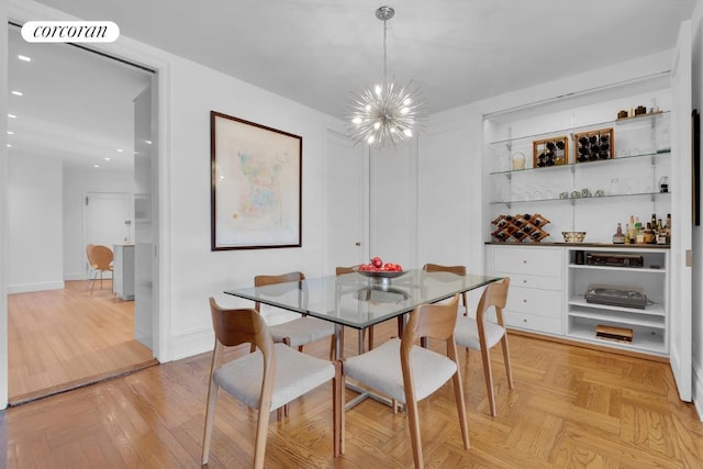 dining space featuring light parquet flooring, indoor bar, and a notable chandelier