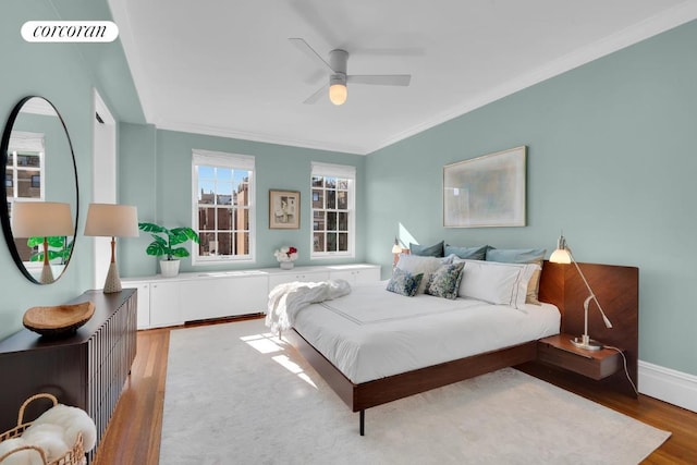 bedroom with crown molding, hardwood / wood-style floors, and ceiling fan