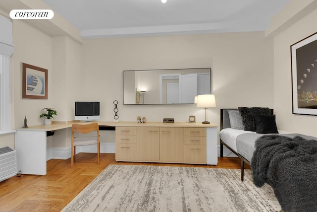 home office featuring light parquet flooring and built in desk