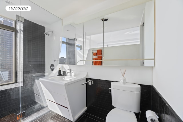 bathroom featuring vanity, a wealth of natural light, a shower with door, and toilet