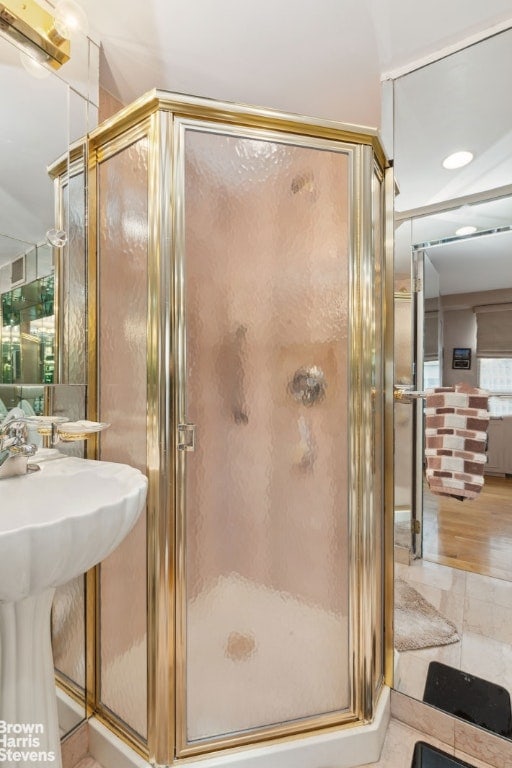 bathroom with sink and a shower with door