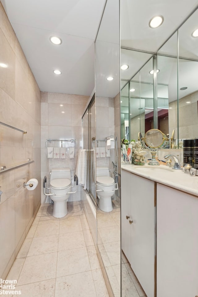 bathroom featuring vanity, a stall shower, tile walls, toilet, and tile patterned floors