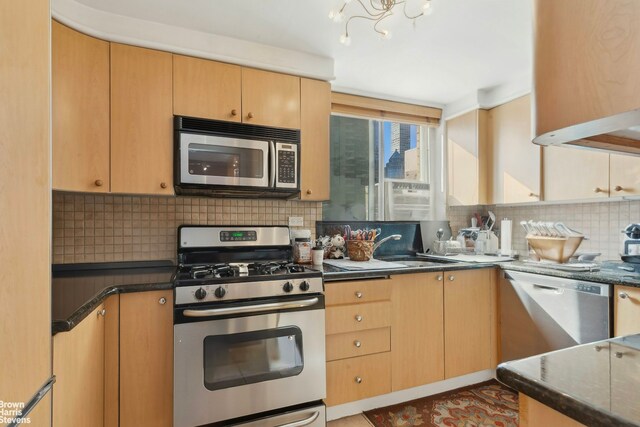 205 E 63rd St Unit 18C, New York City, NY 10065 - kitchen with stainless steel appliances, tasteful backsplash, dark countertops, and a chandelier