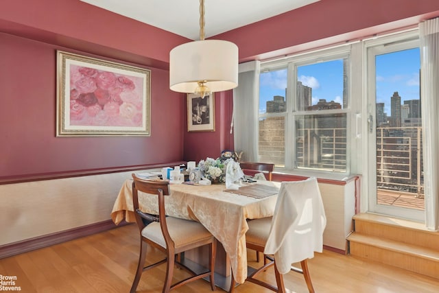205 E 63rd St Unit 18C, New York City, NY 10065 - dining space with a skyline view and light wood-style floors