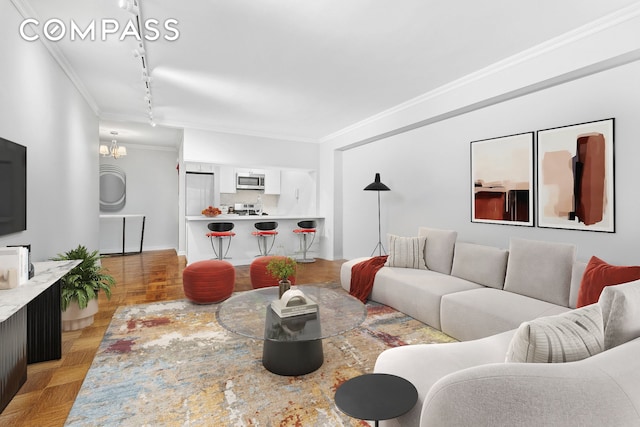 living area featuring track lighting, a notable chandelier, and ornamental molding