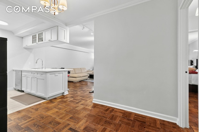 166 E 63rd St Unit 7E, New York City, NY 10065 - kitchen with white cabinets, glass insert cabinets, light countertops, a chandelier, and crown molding