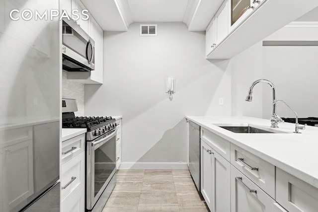 kitchen with visible vents, baseboards, light countertops, appliances with stainless steel finishes, and a sink