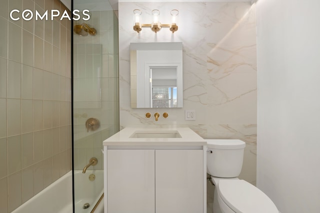 full bath with tile walls, shower / bath combination, toilet, and vanity
