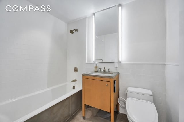 bathroom with vanity, tile walls, toilet, and tiled shower / bath