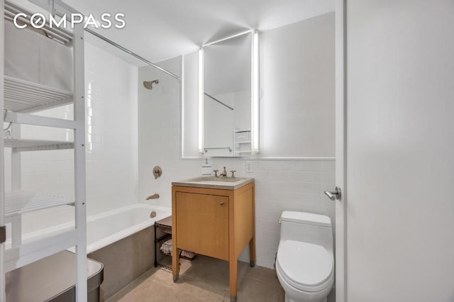 bathroom with vanity, shower / washtub combination, tile walls, toilet, and tile patterned floors